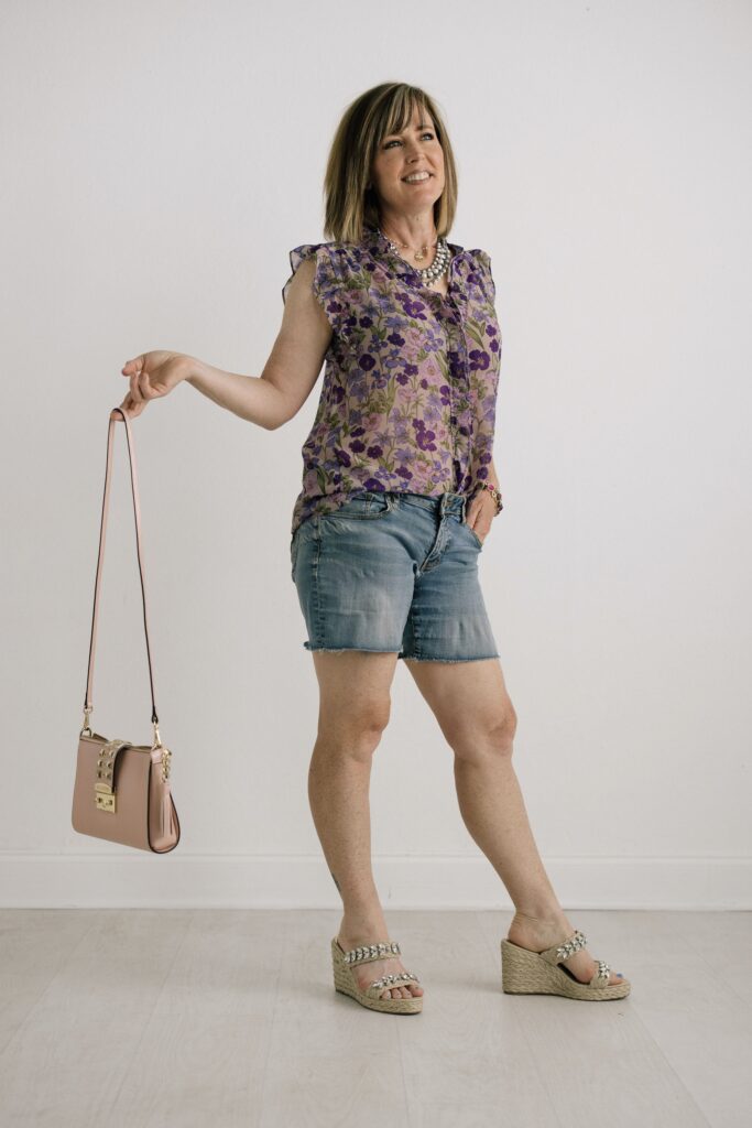 Woman wearing floral blouse with jean shorts