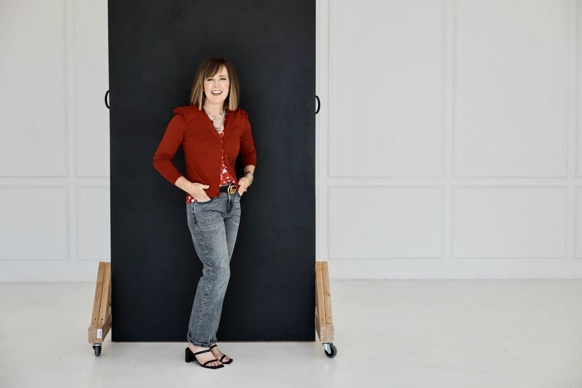 A woman standing in front of a black wall.